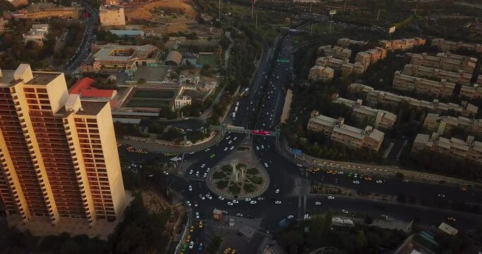 High Angle Aerial Shot Over Towers in Sunset Near the Square in Big City Tehran Iran Cars Drive in Streets Taxi Stop at Taxi Station and Cityscape and Green Spaces in Background Landscape