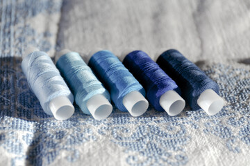 Blue threads. Set of sewing thread coils. Close-up of several bobbins of thread in different shades...