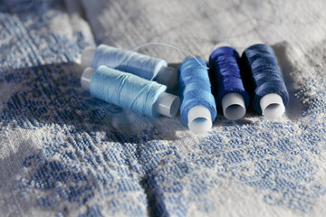 Blue thread. Set of sewing thread coils. Several reels of thread in different shades of blue. White...