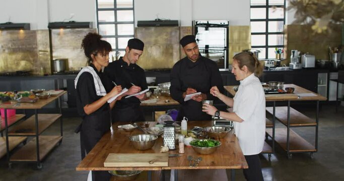 Caucasian female chef teaching diverse group