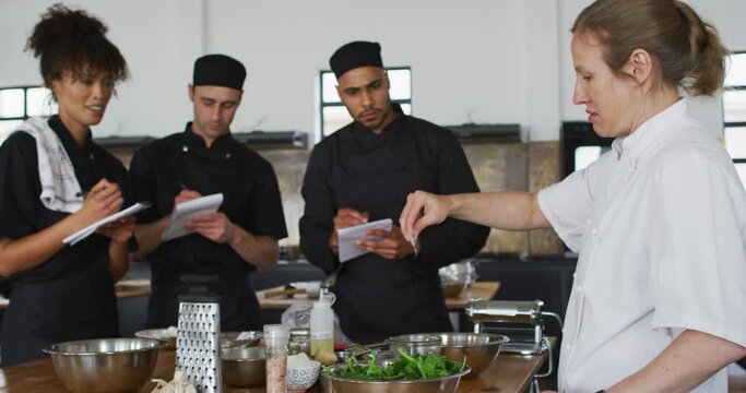 Caucasian female chef teaching diverse group