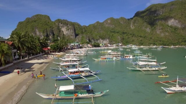 Aerial view of outrigger boats at El Nido beach in El Nido, Palawan Island, Philippines. El Nido is famous for its island hopping tours to secluded beaches and lagoons.