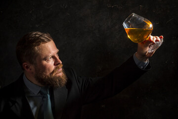 Solid confident bearded man in suit with glass of whisky