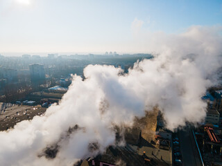 Fototapeta na wymiar Aerial view smoke clouds from boiler pipes on industrial area. Smoking chimney on plant industrial city