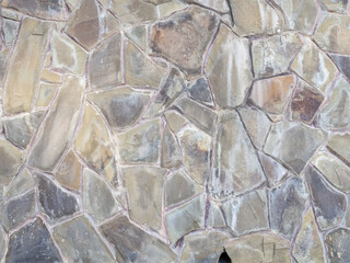 Exterior wall with decorative masonry in many pieces of various shapes and sizes. Background texture