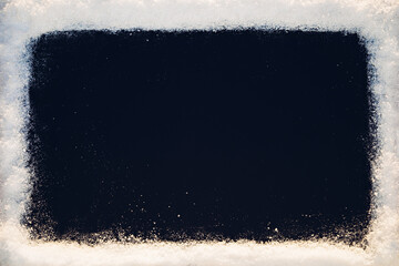 Black background with snow texture frame in sunlight