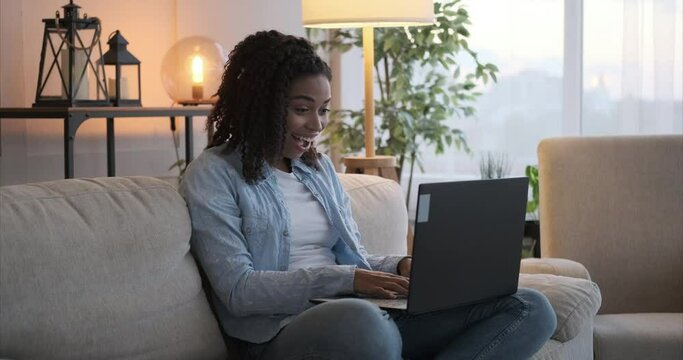 Woman amazed on receiving good news using laptop at home