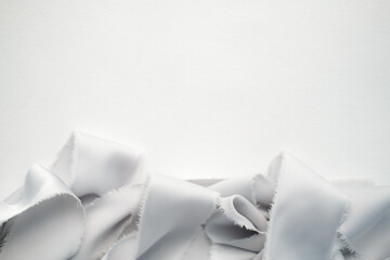 grey and peach silk ribbons on a light background . sewing theme . the view from the top . space for text.