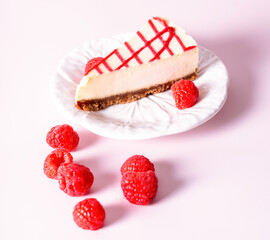 Cheesecake with red raspberries on pink backdrop