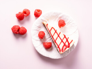 Cheesecake with red raspberries on pink backdrop