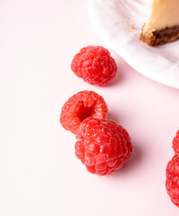 Cheesecake with red raspberries on pink backdrop