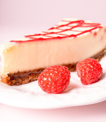 Cheesecake with red raspberries on pink backdrop