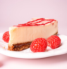 Cheesecake with red raspberries on pink backdrop