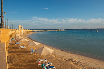 View across an empty tropical beach with stone bridge and arches