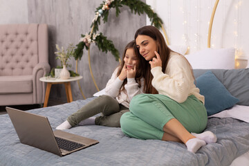 Fototapeta premium mother and daughter make fun of the camera via video link
