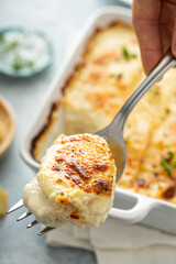 Cheesy scalloped potatoes with thyme and parmesan with a piece taken out