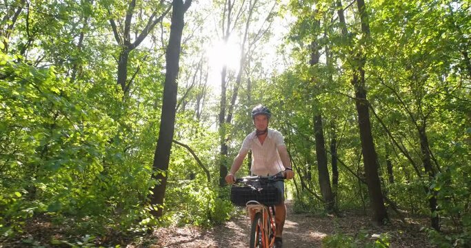 Young male commuter ride on bicycle with halmet in the summer park