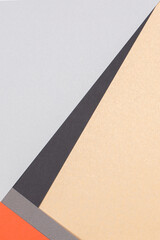 Geometric paper background. Orange, light gray, black and brown craft paper flat lay. Top view