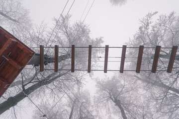 ladder in adrenaline rope adventure playground in winter time with snow