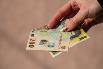 Woman hand giving money like bribe or tips isolated . LEI currency banknotes close up. Reward for...