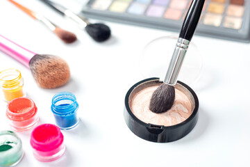 makeup artist hands with brushes and cosmetics for makeup with variety of products and brushes.