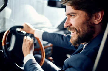 bearded man in suit driving a car luxury trip lifestyle
