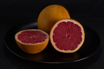 Red grapefruit on black background