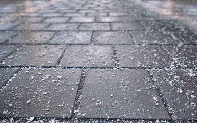 Rock salt (sodium chloride) used on paving slabs and asphalt roads for de-icing. Salt is de-icing...