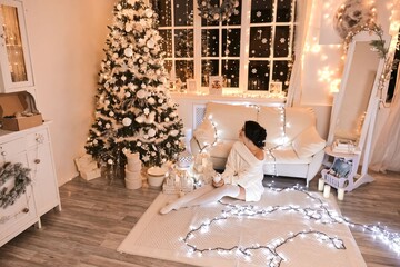 woman in white sweater in Christmas interior design