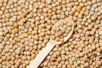 Background with chickpeas and a wooden spoon. Close up.
