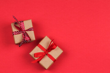 Two gift boxes with bows over a red background. 