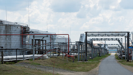 Refinery factory oil storage tank and pipeline steel at day on framatic sky background. Oil refinery plant from industry zone. Oil and gas petrochemical industrial.