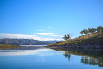 a body of water with hills in the background