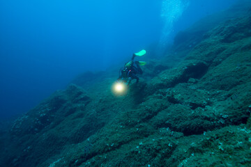 Scuba diver in deep blue sea.