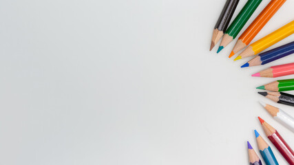 Colorful sketch pencils arrranged to form a circle with white background and space for text