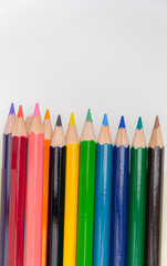 Colorful sketch pencils arrranged to form a circle with white background and space for text