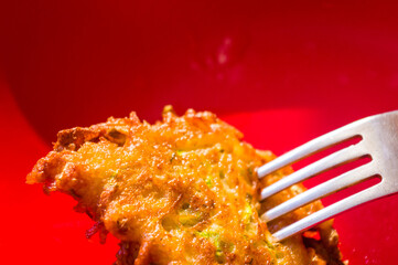 Fried vegetable fritters with zucchini, carrots, herbs, eggs, and cheese.
