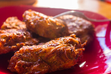 Fried vegetable fritters with zucchini, carrots, herbs, eggs, and cheese.
