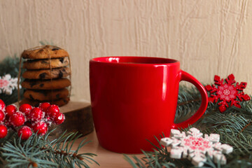 Christmas morning concept. Red cup of coffee with chocolate cookies on festive table with Christmas tree branches and snowflake toys. Festive, holiday mood. Close-up