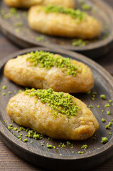 Turkish traditional sherbet dessert kalburabasti on wooden table, dough baked in syrup, handmade dessert concept