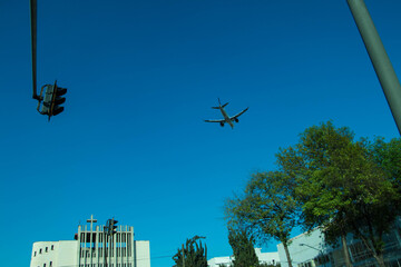avion aterrizando desde lejos en la ciudad hacia el aereopuerto
