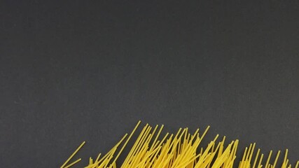 Woman hand puts on the table the pasta dry spaghetti slow motion on a black background - Powered by Adobe