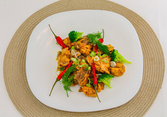 Stir fried chicken with vegetables on a white plate. top view, nobody, concept photo food.