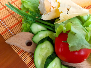 Still life of products - bread, cucumbers, tomatoes, onions, herbs