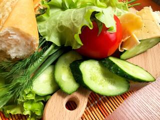 Still life of products - bread, cucumbers, tomatoes, onions, herbs