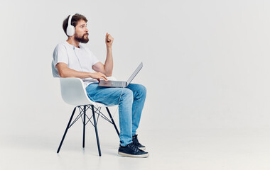 man with headphones in front of laptop sitting on chair communication technology office