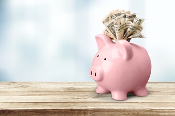 Piggy bank and paper money on desk