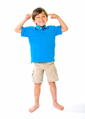Fototapeta premium Young boy in a blue shirt and short pants smiling and standing on a white background