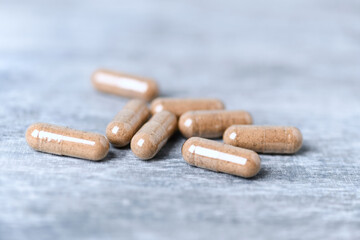 Ashwagandha (Withania somnifera) capsules. Bright wooden background. Close up.	