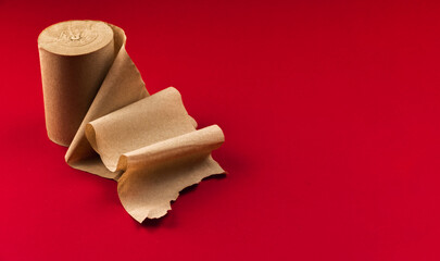 Paper toilet paper for bathroom on red background, unwound roll, space for text, isolated, copy space